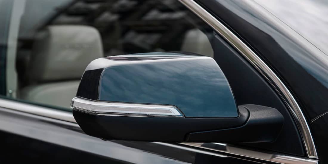 A blue Acadia's sideview mirror